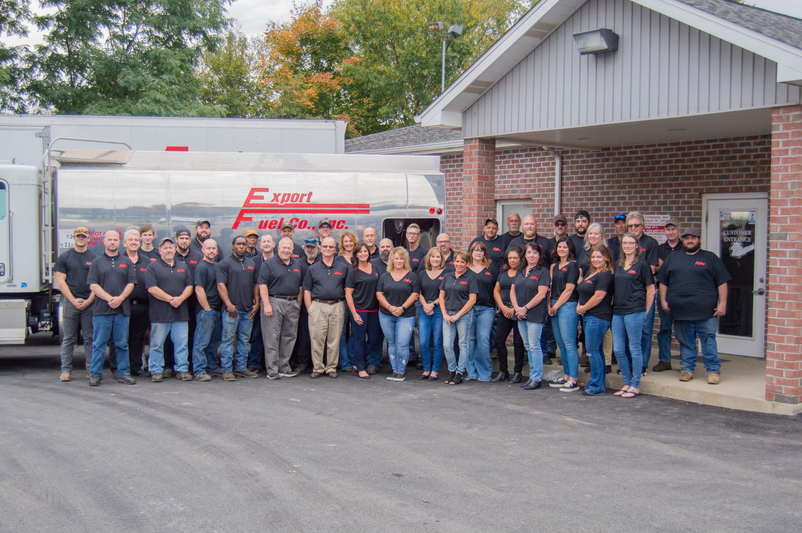 Export Fuel Co. Inc. full staff standing in front of the building and work trucks.
